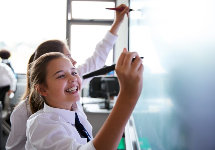 Students writing on the board in class